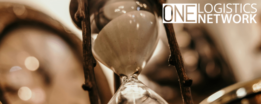 A close-up of a classic hourglass with sand flowing steadily from the top chamber to the bottom, symbolizing the precision and minimal buffers of Just In Time inventory.